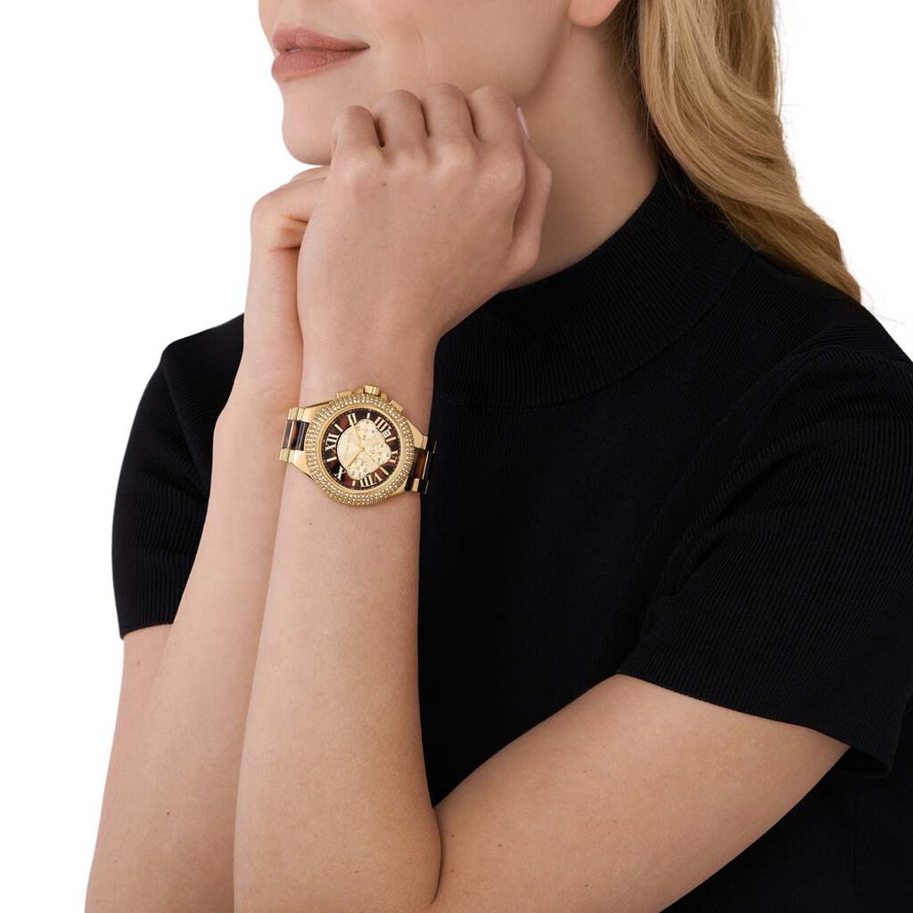 Mujer llevando un reloj marrón de chez Michael Kors