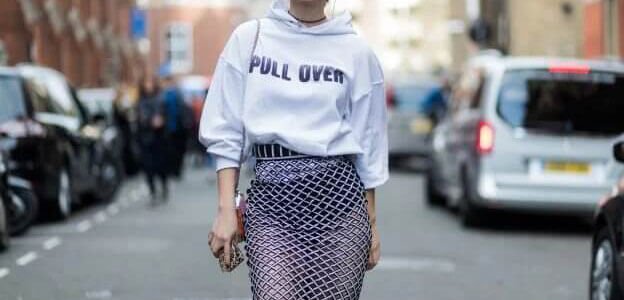 Mujer usando una sudadera con capucha y una falda de red de cintura alta