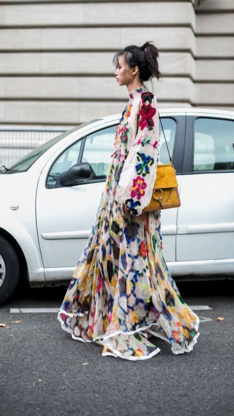 Mujer que lleva un vestido largo con flores en la calle