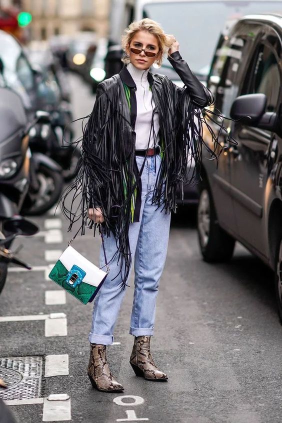 mujer en la calle luciendo un look de primavera con una chaqueta de flecos